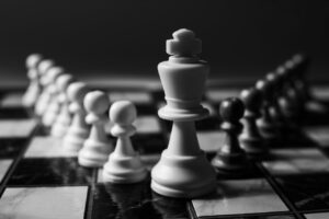 A close-up view of chess pieces on a board, focusing on a king piece, illustrating strategy and decision-making.